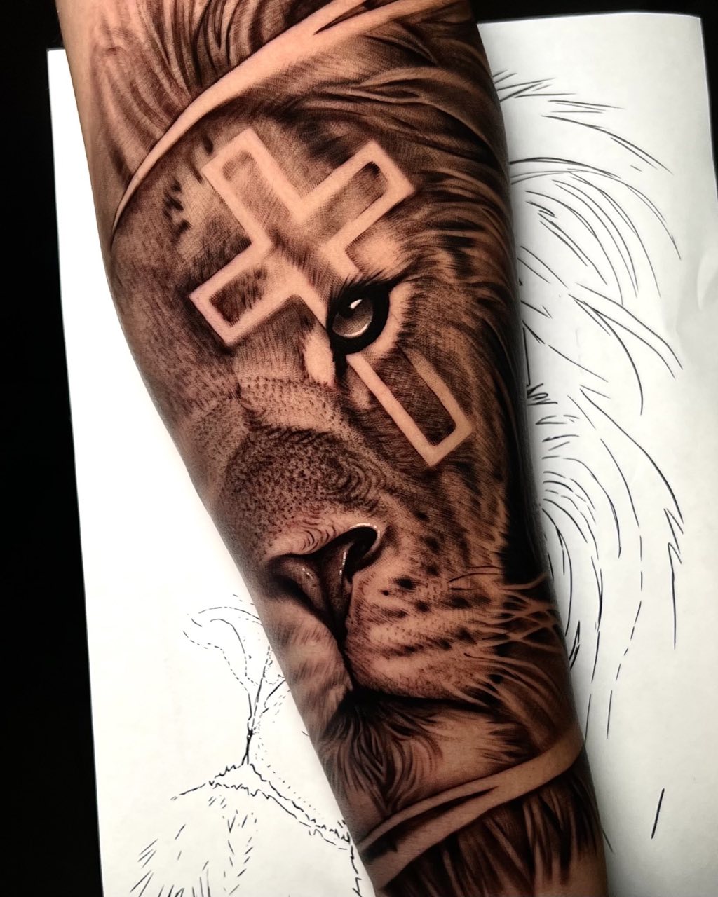 Onderarm met leeuw en kruis, deels nog in lijnwerk, getatoeëerd door Haissam Mokdad