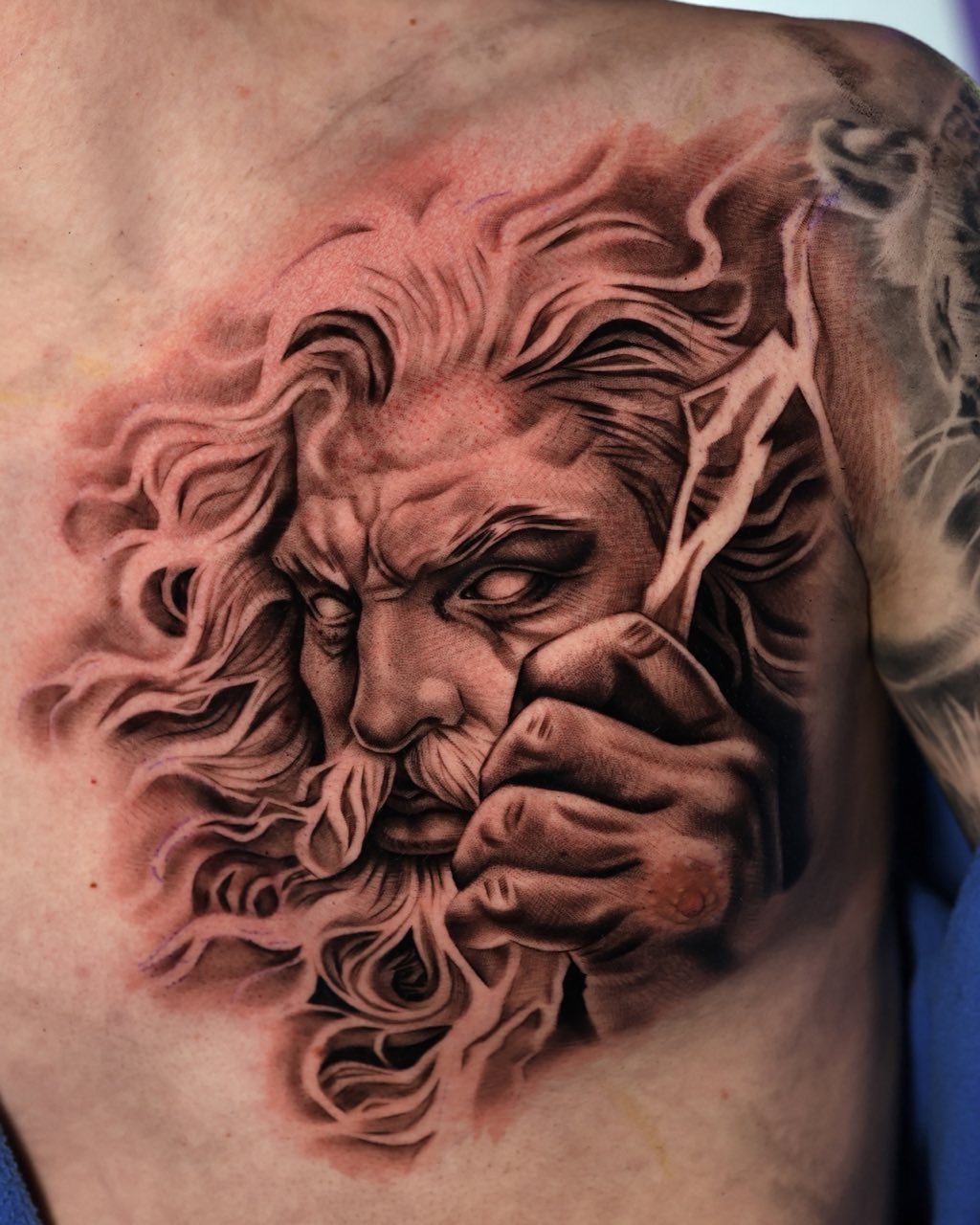 Borststuk van het Zeus-standbeeld met bliksem, getatoeëerd door Haissam Mokdad